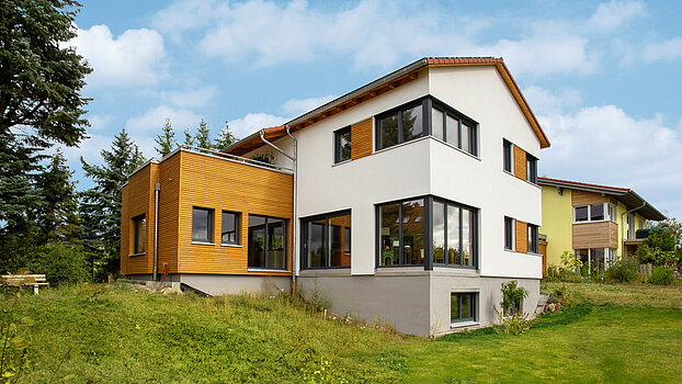 Wohnhaus mit Holzfassade Zweigeschossiges Wohnhaus mit Putz- und Holzfassade und modernem Anbau