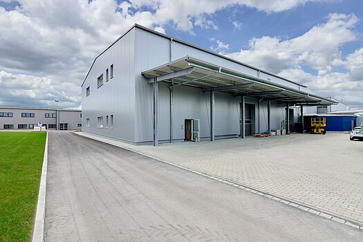Industriehalle mit grauer Fassade und Ladebereich – Gewerbebau von Zimmerei Heinlein