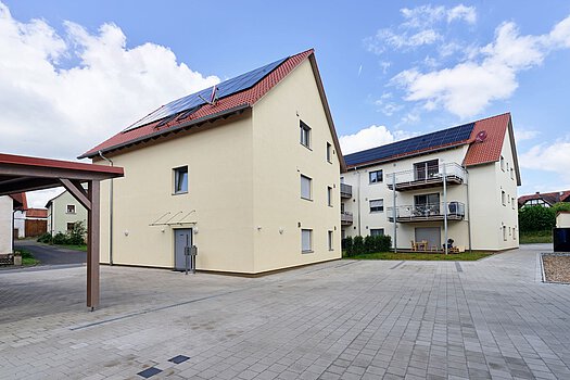 Mehrfamilienhaus mit Photovoltaik Mehrfamilienhaus mit Solaranlage auf dem Dach und großem Vorplatz