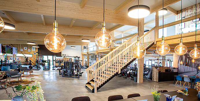 Innenraum mit Galerie und Holztreppe, moderne Beleuchtung – Büro- und Gewerbebau Heinlein