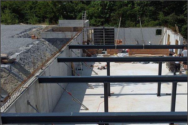 Baustelle der Zimmerei Heinlein in Neustadt an der Aisch mit Fundament und Stahlträgern für neue Produktionshalle im Holzbau