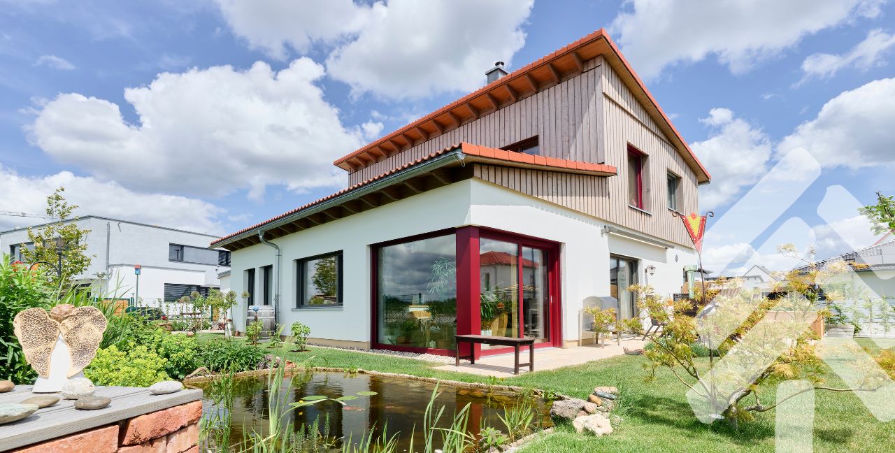 Holzhaus Wohnbau Beispiel Modernes Holzhaus mit Terrasse und roten Fensterrahmen – Wohnbau in Holz